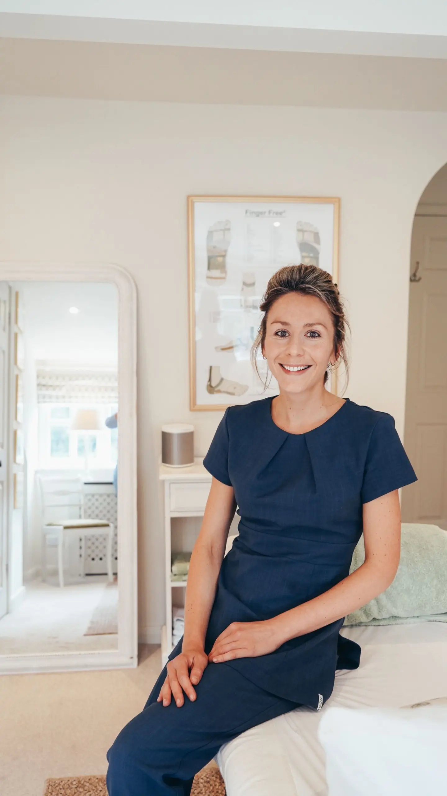 Ellie seated on Rutland Reflexology treatment room treatment bed
